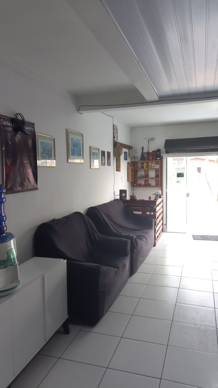 Sala de espera da Barbearia Rock Star, com sofás pretos e ambiente tranquilo