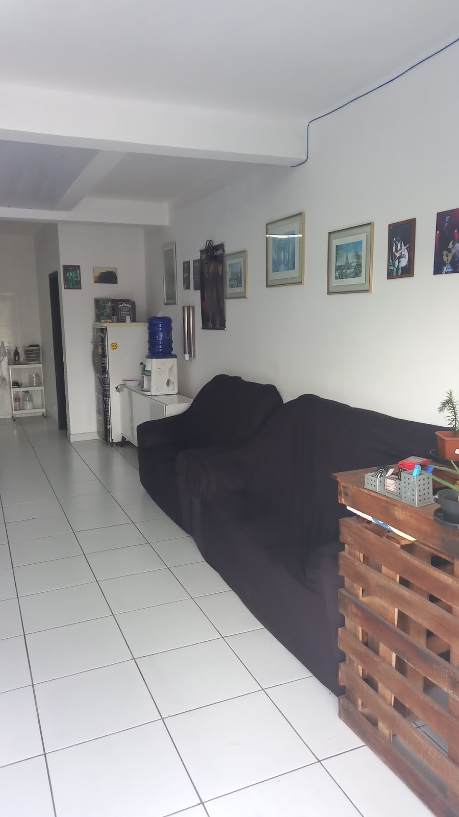 Sala de espera da Barbearia Rock Star com quadros e detalhes de decoração na parede